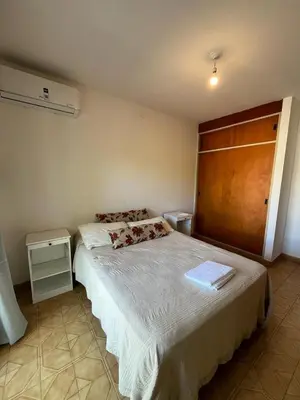 a bedroom with a large bed with a wooden headboard at Departamento Balneario (Centro) in Villa Dolores