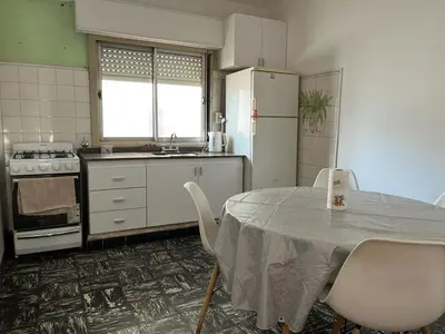 a kitchen with a table and chairs and a refrigerator at Departamento Balneario (Centro) in Villa Dolores