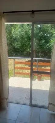 an open glass door with a view of a patio at La Delia in Villa Cura Brochero