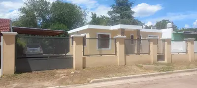a house with a gate with a car in it at La Delia in Villa Cura Brochero