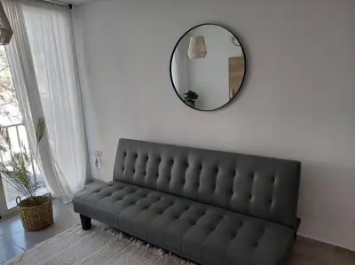 a black couch in a living room with a mirror at Increíble dto de 1 dorm en Nva Cordoba in Cordoba