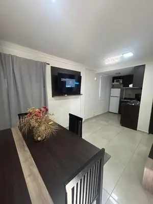 a living room with a table and a kitchen at Miralejos Apart Triplex in Villa Carlos Paz