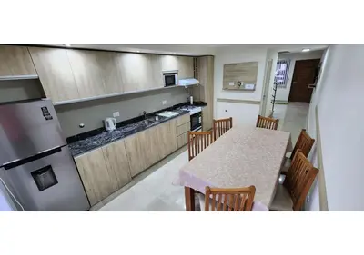a kitchen with a table with chairs and a counter top at Miralejos Apart Triplex in Villa Carlos Paz