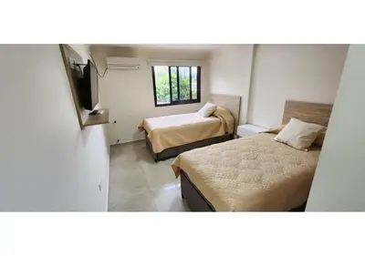 a hotel room with two beds and a television at Miralejos Apart Triplex in Villa Carlos Paz