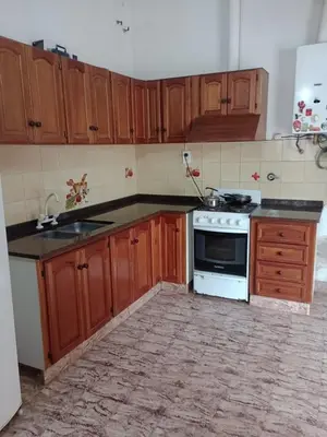 a kitchen with wooden cabinets and a stove top oven at CASA ANTONIA in Embalse