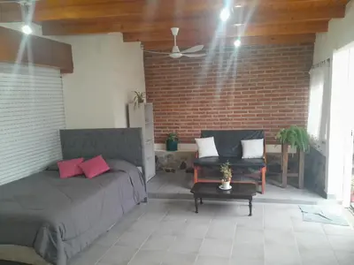 a bedroom with a bed and two chairs and a brick wall at El Vergel in Santa María