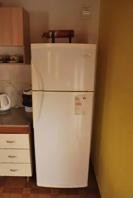 a white refrigerator in a kitchen with a knife on top of it at Departamento cómodo y tranquilo in Villa Carlos Paz