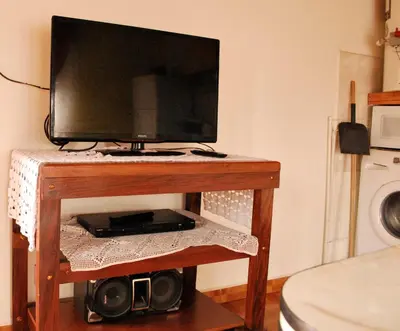 a television on a wooden table in a room at Departamento cómodo y tranquilo in Villa Carlos Paz