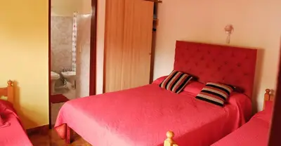 a red bed with two pillows in a bedroom at Departamento cómodo y tranquilo in Villa Carlos Paz