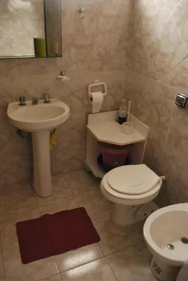 a bathroom with a white toilet and a sink at Departamento cómodo y tranquilo in Villa Carlos Paz