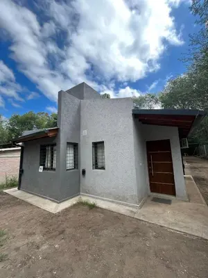 a gray house with a garage and a sky at Villa Simona in Santa Rosa de Calamuchita