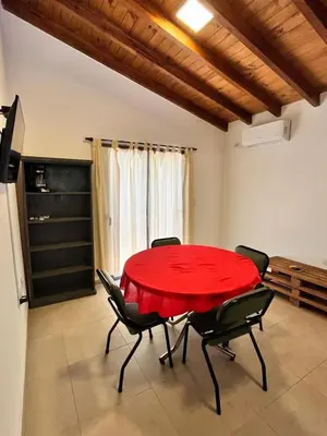 a dining room with a red table and chairs at Villa Simona in Santa Rosa de Calamuchita