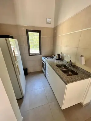 a small kitchen with a sink and a refrigerator at Villa Simona in Santa Rosa de Calamuchita