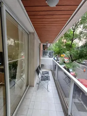 a screened porch with a chair and a table at Hermoso departamento doble be in Cordoba
