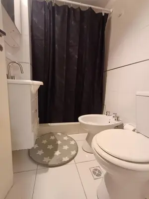 a bathroom with a toilet and a black shower curtain at Hermoso departamento doble be in Cordoba