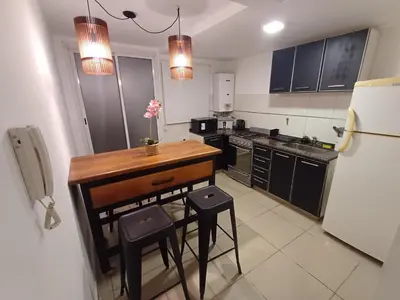 a small kitchen with a table and a refrigerator at Hermoso departamento doble be in Cordoba