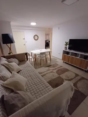 a living room with a large bed and a table at Hermoso departamento doble be in Cordoba