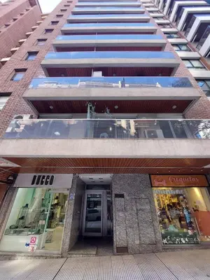 a tall building with a store in front of it at Hermoso departamento doble be in Cordoba
