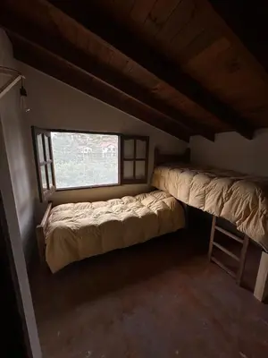 a small room with two beds and a window at Casa La Boticaria in La Cumbrecita