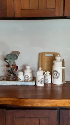 a shelf with a bunch of white pots and pans at Casa La Boticaria in La Cumbrecita