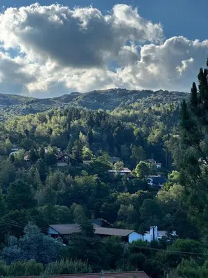 a view of a valley with trees and houses at Casa La Boticaria in La Cumbrecita