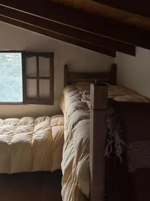 a large bed in a bedroom with a window at Casa La Boticaria in La Cumbrecita