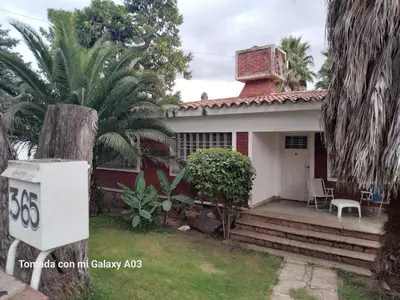 a house with a brick chimney and a porch at Alquiler temporario villa Carlos Paz in Villa Carlos Paz