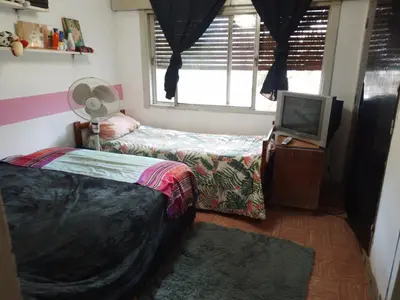a bedroom with two beds and a tv and a window at Alquiler temporario villa Carlos Paz in Villa Carlos Paz