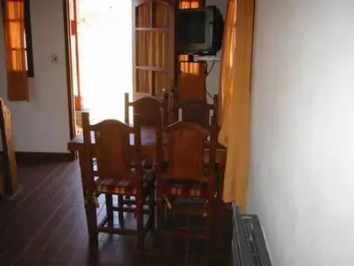 a dining room with chairs and a tv in a room at Cabañas Oma Lissi in Merlo