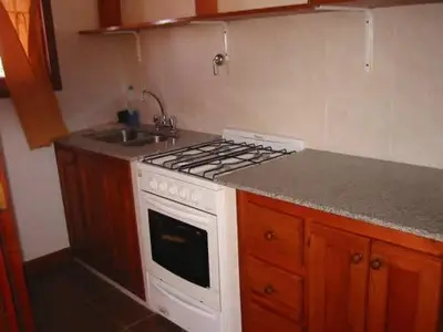 a kitchen with a white stove and a sink at Cabañas Oma Lissi in Merlo
