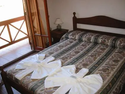 two white bows on a bed in a room at Cabañas Oma Lissi in Merlo