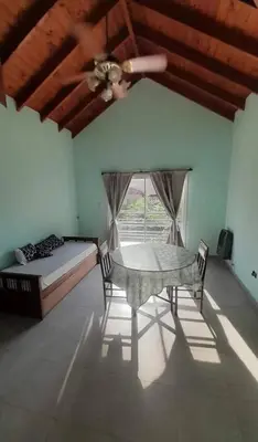 a bedroom with a table and a bed and a ceiling fan at Tantanakuy 2 in Villa General Belgrano