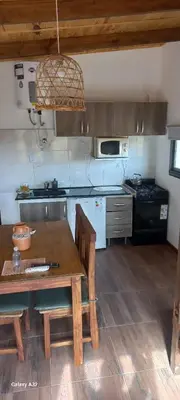 a kitchen with a wooden table and a kitchen with a stove at Portezuelo de árboles in Panaholma