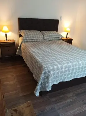 a bedroom with a bed with a blue and white blanket at Portezuelo de árboles in Panaholma