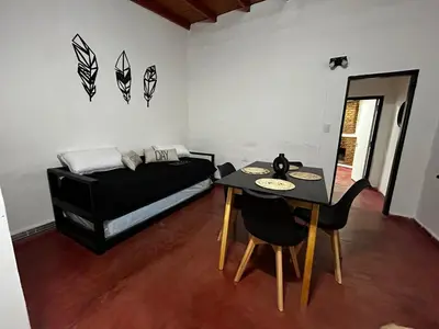 a room with a bed and a table and chairs at Departamentos MarCor in Nono