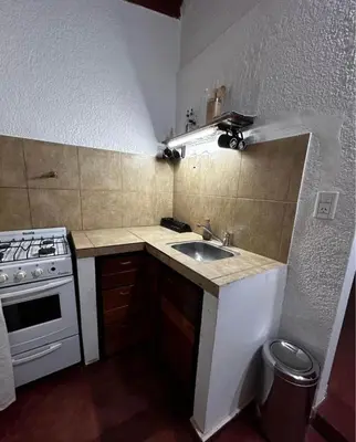 a small kitchen with a sink and a stove at Departamentos MarCor in Nono