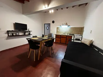 a room with a table and chairs and a kitchen at Departamentos MarCor in Nono
