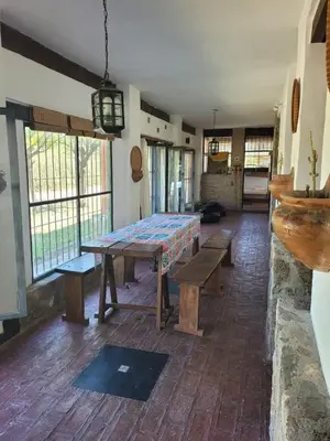 a room with a table with benches and windows at Casona y Casa de Campo in Santa María