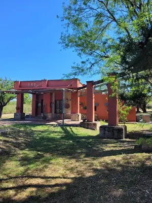 an orange building with a tree in the yard at Casona y Casa de Campo in Santa María