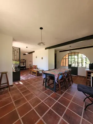 a living room with a table and a room with a floor at Casona y Casa de Campo in Santa María