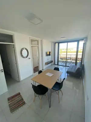 a dining room with a table and chairs in a room at Dalcar Apart in Río Cuarto