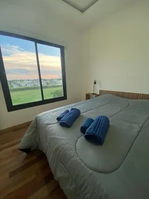 a bedroom with a large bed with blue pillows on it at Dalcar Apart in Río Cuarto