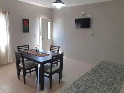 a dining room with a black table and chairs at HERMOSO DEPARTAMENTO EN QUINES in Quines
