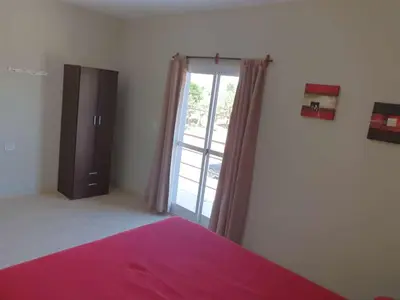 a bedroom with a bed and a large window at HERMOSO DEPARTAMENTO EN QUINES in Quines