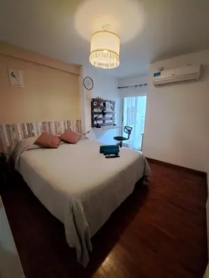 a bedroom with a large bed and a chandelier at Departamento -Torre Duomo- a 50mts de la Terminal de Ómnibus de lado de Barrio Nueva Cordoba, By Apartcba in Cordoba
