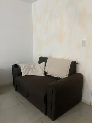 a black couch with two pillows on top of it at Departamento -Torre Duomo- a 50mts de la Terminal de Ómnibus de lado de Barrio Nueva Cordoba, By Apartcba in Cordoba