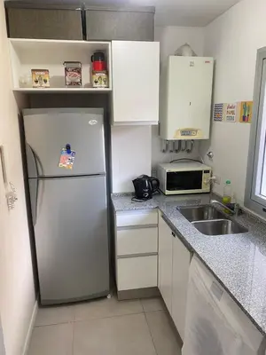 a small kitchen with a refrigerator and a sink at Departamento -Torre Duomo- a 50mts de la Terminal de Ómnibus de lado de Barrio Nueva Cordoba, By Apartcba in Cordoba