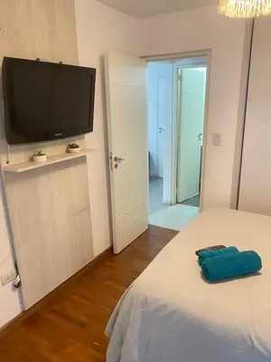 a bedroom with a bed with a flat screen tv at Departamento -Torre Duomo- a 50mts de la Terminal de Ómnibus de lado de Barrio Nueva Cordoba, By Apartcba in Cordoba