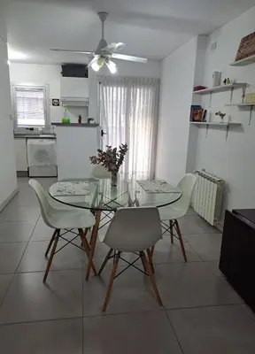 a dining room with a glass table and chairs at Departamento -Torre Duomo- a 50mts de la Terminal de Ómnibus de lado de Barrio Nueva Cordoba, By Apartcba in Cordoba