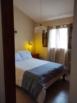 a bedroom with a large bed and a window at Alberobello Casa Serrana in Santa Rosa de Calamuchita